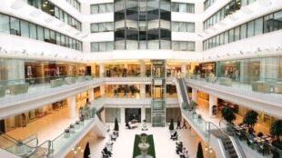 Interiör av ett stort, modernt köpcentrum och kontorskomplex i flera våningar.