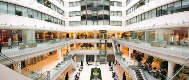 Interiör av ett stort, modernt köpcentrum och kontorskomplex i flera våningar.